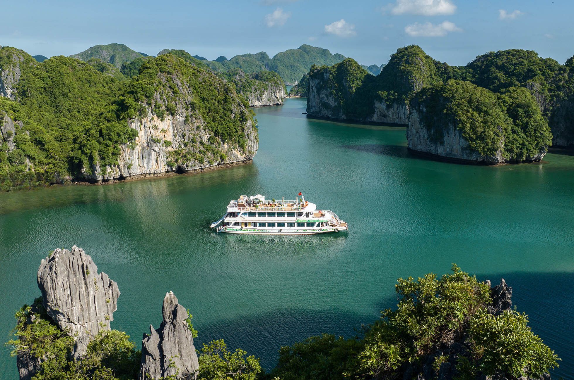 Luxury private cruise sailing through Ha Long Bay limestone islands, Vietnam